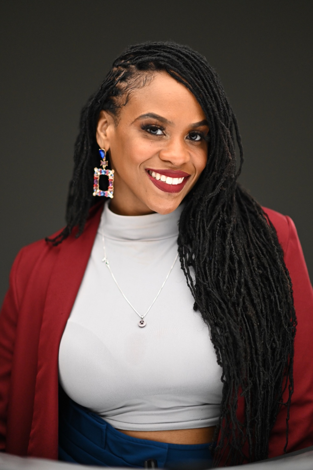 Akilah smiling in a red blazer